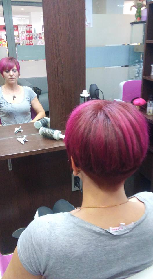 Client with short pink hair in a salon setting