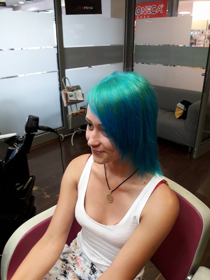 Client with vibrant blue hair in a salon chair